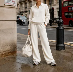 Detailed street style view of casual white zip-up sweatshirt and wide leg trousers set.
