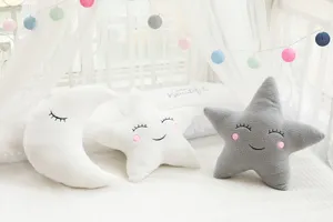 Plush moon and star throw pillows, cute embroidered facial design, soft nursery decor.