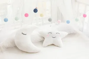 Detailed view of the cute white plush moon and star throw pillows with sweet embroidery design.