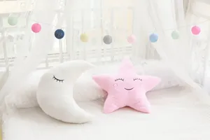 Soft plush moon and star throw pillows with cute embroidered facial expressions for kids room decor.