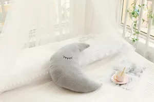 Cozy grey crescent moon plush pillow detailed scene in a bright modern bedroom setting.