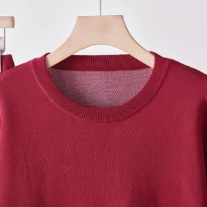 Gros plan sur pull en tricot rouge, detail texture douce, vetement confortable debut automne.