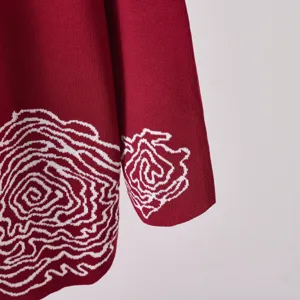 Gros plan détail du pull en tricot rouge pour femme avec beau motif blanc abstrait.
