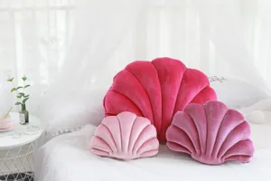 Vista dettagliata di cuscini in peluche a forma di conchiglia rosa per decorazioni.