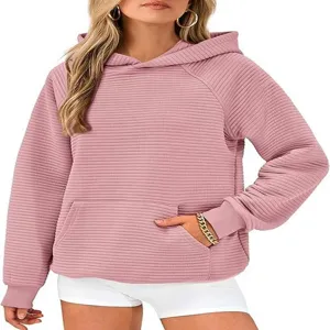 Gros plan sur le sweat à capuche rose côtelé pour femme avec poche avant et manches.