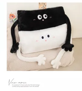 Gros plan du long oreiller en peluche créatif avec des bras mignons et broderie sur le lit.