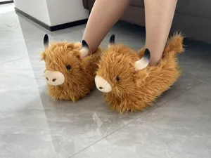 Primo piano di simpatiche pantofole di peluche di mucca per comfort invernale.