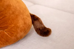 Close-up detail shot of the soft brown plush toy tail, showcasing fine texture and fluffy material.