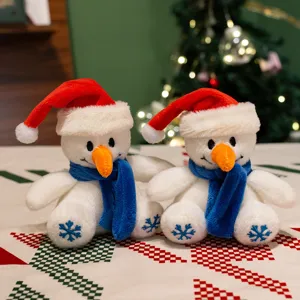 Detail de peluche bonhomme de neige de Noel, bonnet rouge et echarpe bleue, decor festif.