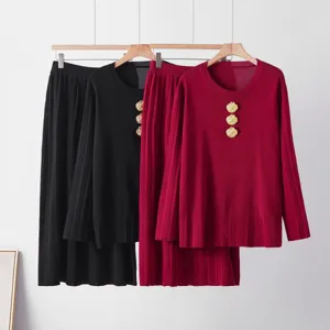 Ensemble pull en tricot et jupe plissée avec de beaux boutons dorés et manches longues.