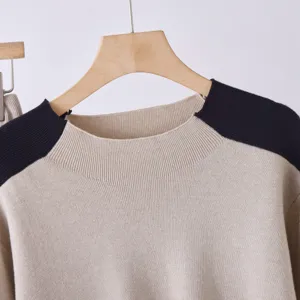 Detailopname van de gebreide trui met hoge kraag en contrasterende schouders voor winter.