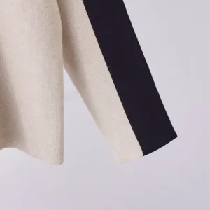 Close-up van het stijlvolle kleurblokgebreide truimouwtje, perfect voor herfstmode.