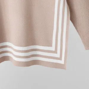 Detailed view of women's stylish knit sweater with contrast stripes, cozy autumn fashion.