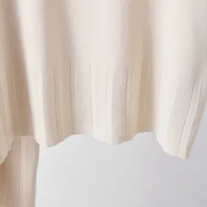 Vue de détail rapprochée du pull en tricot beige présentant une texture fine et côtelée.