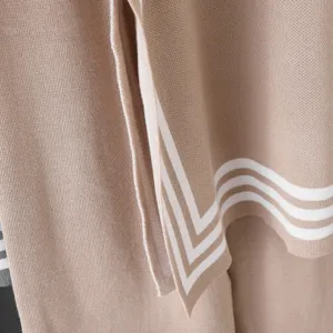 Knitted sweater fabric detail, soft texture and stylish white striped trim design.
