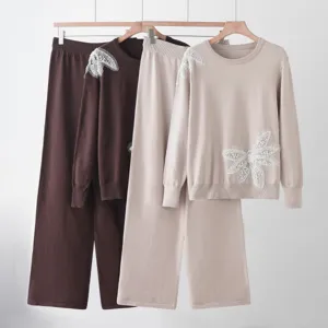 Knit sweater and wide-leg pants set detail showing delicate beaded butterfly decorations.