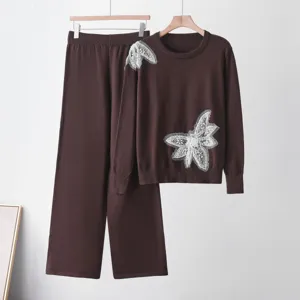 Detail view of the brown knit sweater and pants set featuring elegant pearl butterfly appliques.