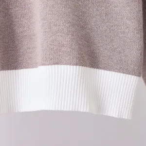 Close-up detail of a stylish color-blocking knit sweater hem, soft texture and cozy wear.