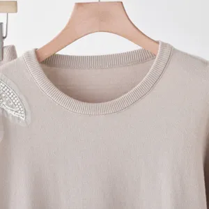 Beaded butterfly knit sweater detail, cozy round neck pullover, elegant autumn style.