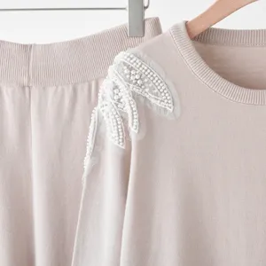 Chic beaded knitted sweater set with elegant shoulder embroidery, stylish autumn outfit.