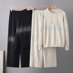 Vista dettagliata della elegante tuta in maglia con cappuccio e sfumatura di strass.