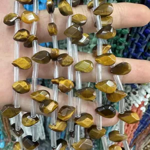 Detalle macro de cuentas de ojo de tigre facetadas para hacer joyas artesanales