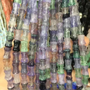 Macro detail of 8x12mm natural stone bamboo joint beads in mixed colors for DIY jewelry.
