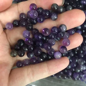 Detailed macro shot of natural purple amethyst round beads for DIY jewelry crafting.