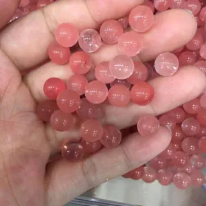 Macro view of polished pink rose quartz round beads for DIY jewelry making and craft projects