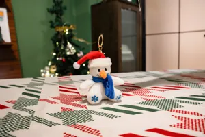 Adorable porte-clés en peluche bonhomme de neige de Noël avec bonnet rouge et écharpe bleue.