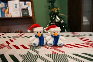 Adorable bonhomme de neige en peluche avec bonnet rouge et écharpe bleue, détail de décoration.