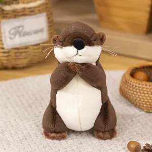Detailed close-up view of cute brown plush otter toy with praying hands in cozy indoor scene.