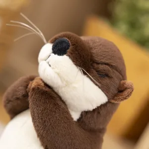 Cute plush otter toy face close-up, soft brown fur and closed eyes blessing expression.
