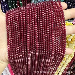 Gros plan de petites perles rondes en jade rouge naturel à texture translucide