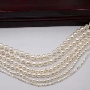 Vue détaillée de perles de coquillage blanches de différentes tailles pour bijoux DIY.