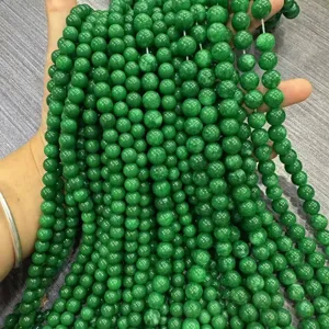 Detailed view of polished vibrant green Malaysian jade round beads for jewelry making