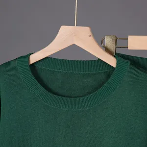Close-up view of the dark green knit sweater collar and texture details, elegant and soft.