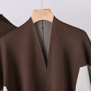 Detail shot of women's knit cardigan shawl, brown and white jacquard pattern, soft fabric.