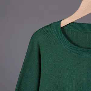 Detailed view of the dark green knitted sweater collar, soft texture and fine ribbing.