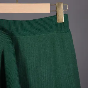 Green knit sweater detail, soft ribbed texture, comfortable casual autumn winter ladies top.