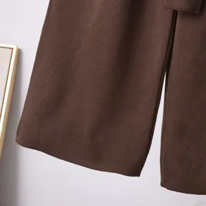 Detail view of brown knitted wide-leg trousers showing fine rib-knit texture and soft fabric.