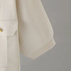 Detailed view of the beige knitted sleeve and pocket texture, showing high-end fabric quality.