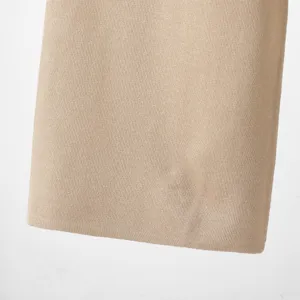 Close-up detail shot of the soft beige knit fabric texture, showcasing fine stitching.
