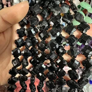 Close-up view of 12mm faceted black stone clover-shaped beads for DIY jewelry making