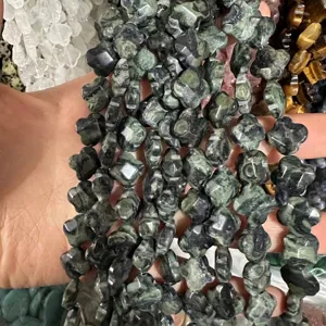 Close-up of faceted clover natural stone beads held in hand for DIY jewelry making