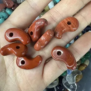 Detailed macro view of natural red jasper comma-shaped stone pendants for DIY jewelry