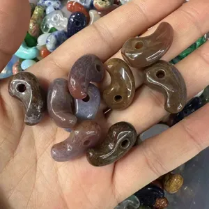 Macro view of assorted natural agate stone comma pendants for DIY jewelry making