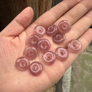 Close-up macro view of 15mm natural strawberry quartz crystal safety buckle donut beads