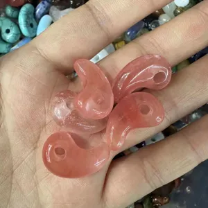 Close-up of pink natural stone comma-shaped pendants for DIY jewelry making