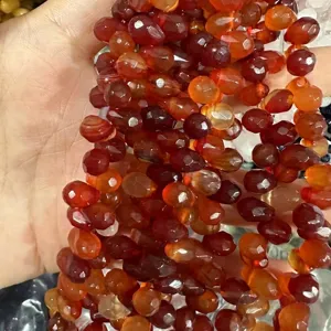 Vue détaillée de perles goutte en agate rouge naturelle facettée pour bijoux artisanaux.
